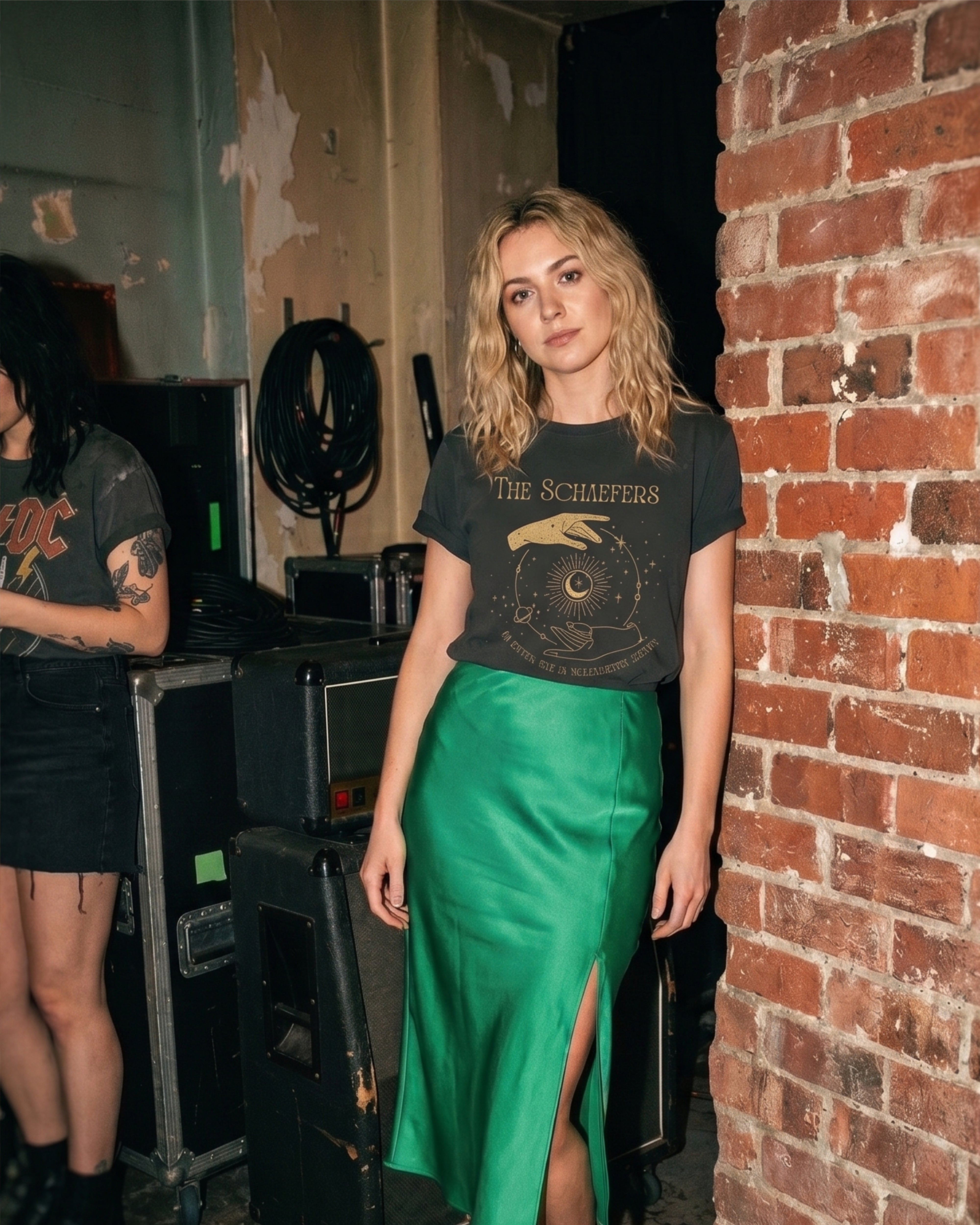 Frau mit personalisiertem Bandshirt mit ihrem eigenen Nachnamen  im Vintage Design von "THE LAST NAME BAND" steht im CLub angelhnt an einer Backsteinwand.